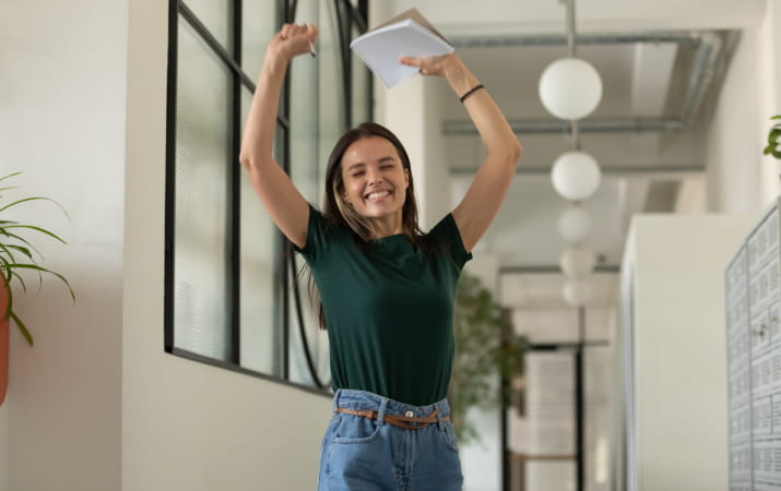 An excited woman celebrating with her hands in the air