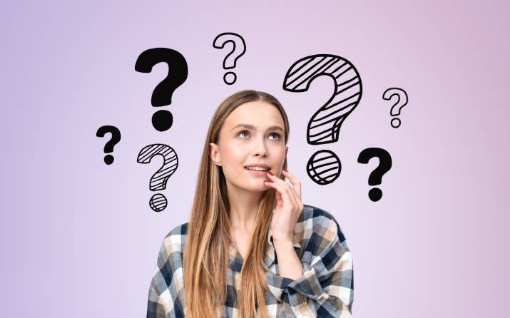 A woman thoughtfully gazing at question marks floating above her head as she questions how university fees work