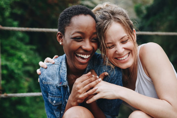 Two women laughing and hugging