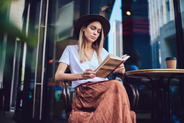 A young woman reading a book at a cafe